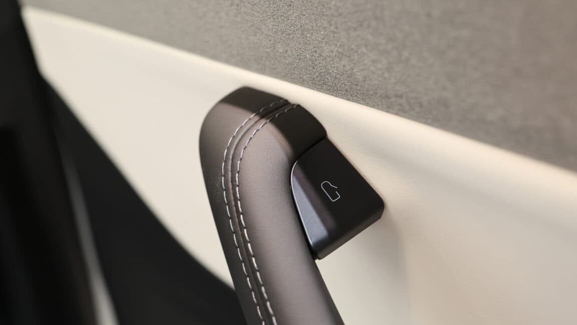 A modern electric vehicle interior showcasing digital dashboard and steering controls.